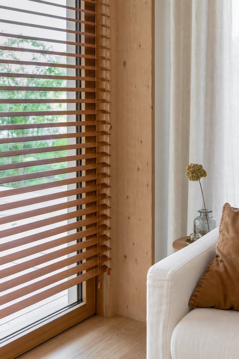 Holzjalousien vor Holzwand und Fenster